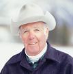Senior man wearing cowboy hat standing in snow