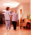 Nurse assisting elderly woman walking