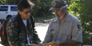 A photo of a volunteer giving a camera to a visitor for a research project.