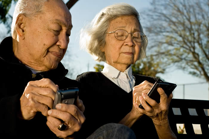 A man and a woman using palm pilots