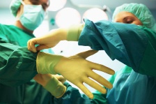 Surgeon putting gloves on