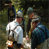 group of biologists standing in a creek and holding a net filled with material
