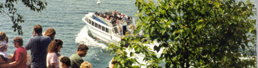 Visitors enjoy the view from Miners Castle as a Pictured Rocks Cruise boat passes by.