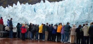 Cruise ship passengers view tidewater glacier.