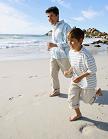 father and son running on the beach