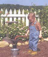 Image of a small boy standing by a well pump