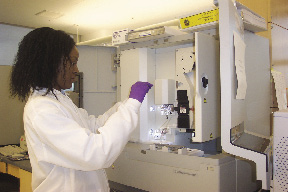 Photo of A DNAAU-1 biologist injecting a reagent into an analytical instrument.