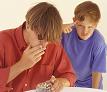 Boy standing next to man smoking