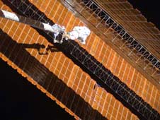 Astronaut repairs solar wing.
