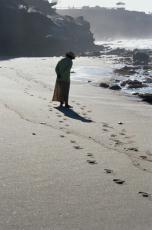 Photograph of a woman walking on a beach