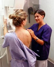 Photograph of a woman having a mammogram and a female technician
