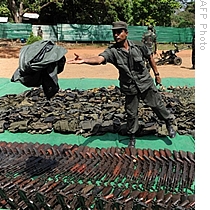 A Sri Lankan soldier uncovers weapons which according to the army were captured from the Liberation Tigers of Tamil Eelam (LTTE) in Kilinochchi, 24 Apr 2009