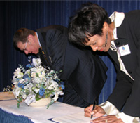 FBI public affairs exec Cassandra Chandler and NCAAA President Jerry Fogel sign the Memorandum of Understanding.