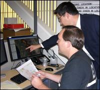 FBI computer scientist Teddy Lindsey (standing) shows his geo-location tool to a member of the Sheriffs' department