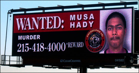 Digital billboard showing wanted fugitive Musa Hady