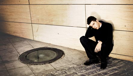 photo of a young person crouching against the wall