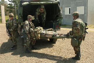 Airmen off-load a casualty on a stretcher from a HUMMV