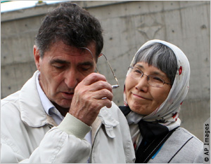 Couple standing in front of concrete wall (AP Images)