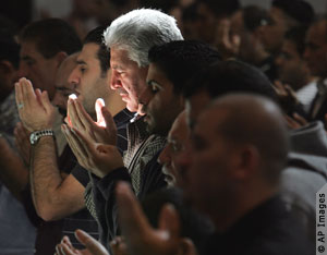 Line of men praying (AP Images) 