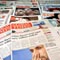 Newspapers on a table (AP Images)