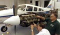 Profesor de mecánica de aviación revisa el motor de un avión.