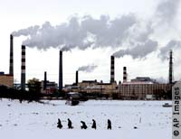 People in snow, stacks issuing smoke (AP Images)