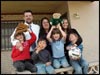 [Photo: The Brewer family smile proudly in front of their new home]