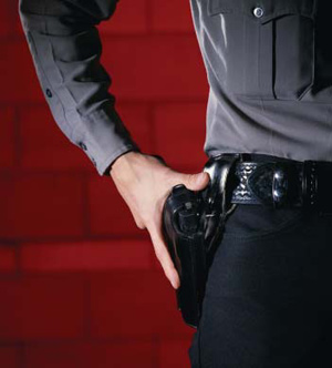 Photograph of police officer with his hand on his side weapon holster
