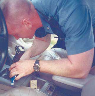 Photograph of police officer searching the center console of  vehicle