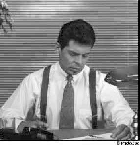 Photograph of business professional man sitting at a desk and writing