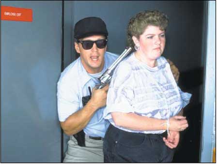 Photograph of man holding a woman hostage at gun point