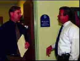 Photograph of two police detectives talking in the office