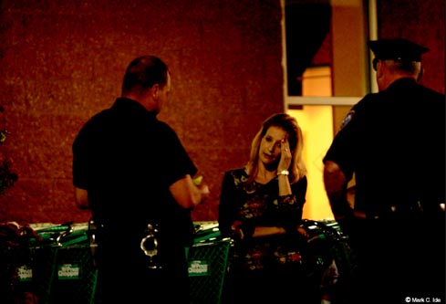 Photograph of police officers talking to a woman who appears distraught