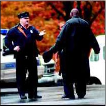 Photograph of police officers talking to a man on the street