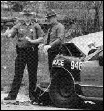 Photograph of Two State Troopers Standing in fron of wrecked State Police car