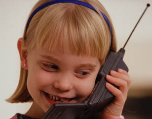 young girl using large old-style cell-phone - photo courtesy NASA.gov