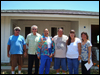 [Photo: New homeowner and group in front of home being built]