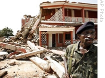 A soldier stands outside a collapsed section of the military HQ in Bissau where a bomb killed the armed forces chief of staff, 03 Mar 2009