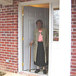 Miss Myrtle Brown greets well wishers from the front door of her new home.