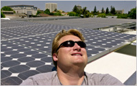 A manager standing next to solar panels