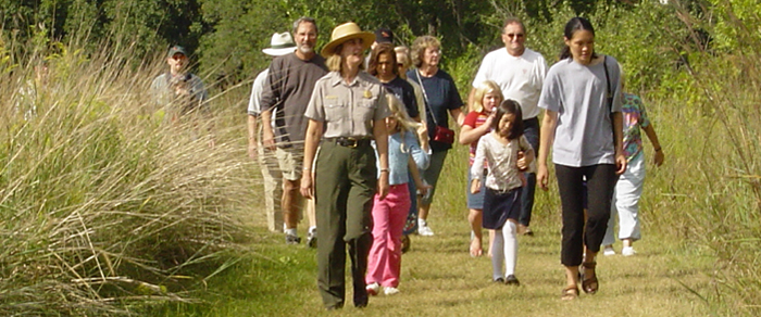 A ranger leads a group of visitors along a trail at Herbert Hoover National Historic Site in Iowa.