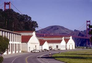 A photo of the buildings and open spaces at Crissy Field, with the Golden Gate Bridge in the background.