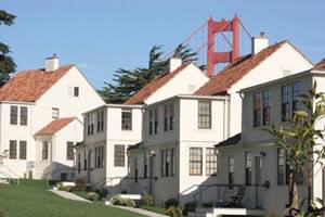 A photo of four homes in the Storey neighborhood with the Golden Gate Bridge in the background.