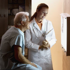 Fotografía de un paciente y una doctora mirando una radiografía