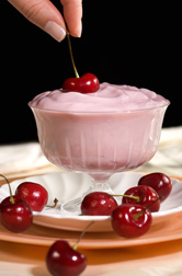 Yogurt in a glass serving dish and cherries: Click here for full photo caption.