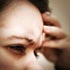 Photo of a woman holding her head in pain