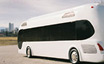 Photo of a small white model of bus with downtown Denver in background.