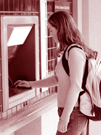 A picture of a girl using an ATM