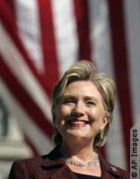 Head shot of Hillary Clinton with flag backdrop (AP Images)