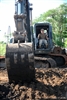 Petty Officer 3rd Class Justian Fordt operates a back hoe.